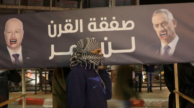 فلسطينيون يحملون نعشًا وهمياً يحمل صورة السياسي والجنرال الإسرائيلي المتقاعد بيني غانتس (يمين) وعبارة "صفقة القرن لن تمر" في مدينة نابلس في الضفة الغربية المحتلة في 28 يناير/كانون الثاني 2020