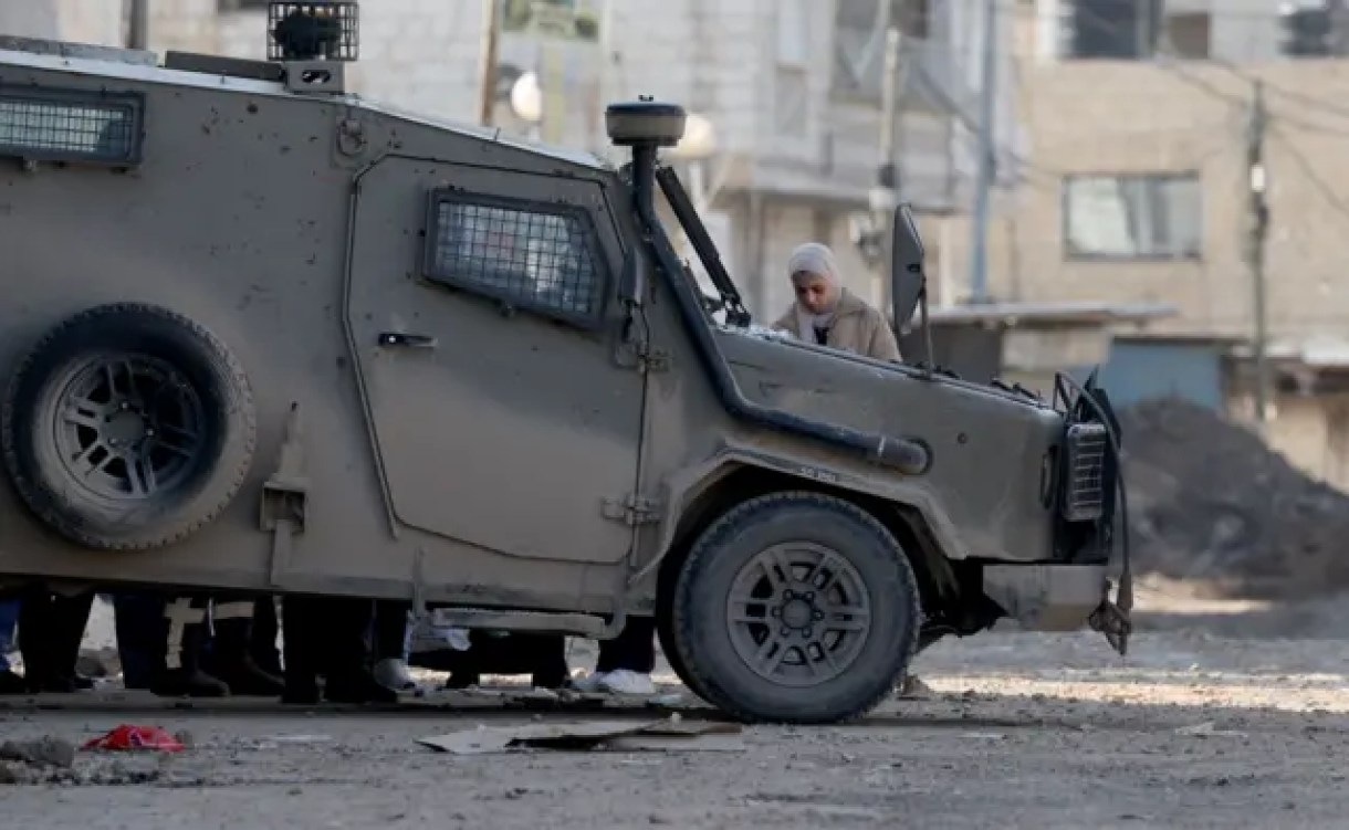 مركبة عسكرية إسرائيلية بجوار فتاة فلسطينية في جنين 29 يناير/كانون الثاني