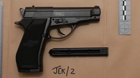 تاج خدمة الادعاء دليل شرطة صورة للمسدس الأسود على ورقة بيج بجانب الحاكم