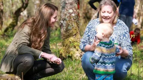 رويترز كاثرين تربط بالتحدث إلى طفل صغير ذو شعر عادل وهو طقم أزرق وأخضر يساعده امرأة ذات شعر أشقر ترتدي قمة زرقاء وبيضاء وأزرق وأزرق