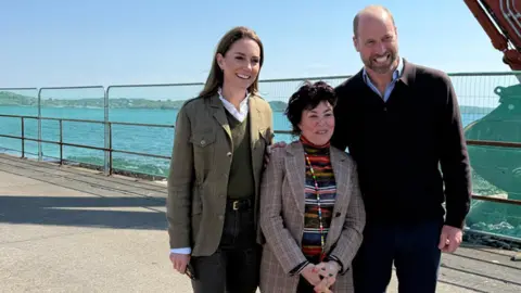 كاثرين وويليام يطرحان صورة مع شمع روبي وهي امرأة قصيرة ذات شعر مظلم قصير