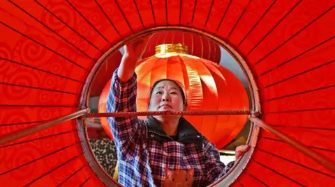 Getty Images ينتج العامل فوانيس في مصنع في يانتاي ، في مقاطعة شاندونغ في شرق الصين في 8 يناير 2024.