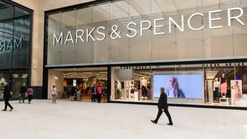 الأشخاص الذين يسيرون أمام متجر Marks & Spencer