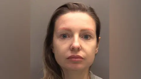 CPS A Police Mugshot of Kerri Pegg ، 42 ، الذي يعاني من شعر أشقر وعيون زرقاء ، ويحدق في الكاميرا مع تعبير فارغ