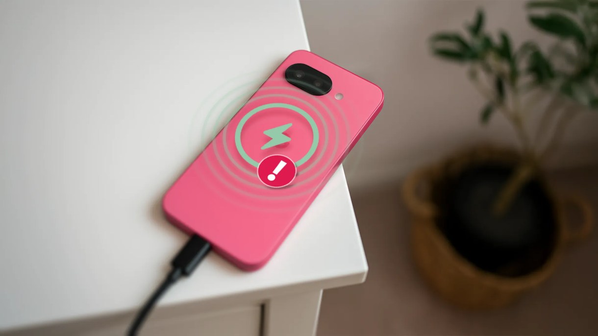 A Google Pixel 9A ملقاة على طاولة أثناء الشحن ، مع أيقونة تحذير.